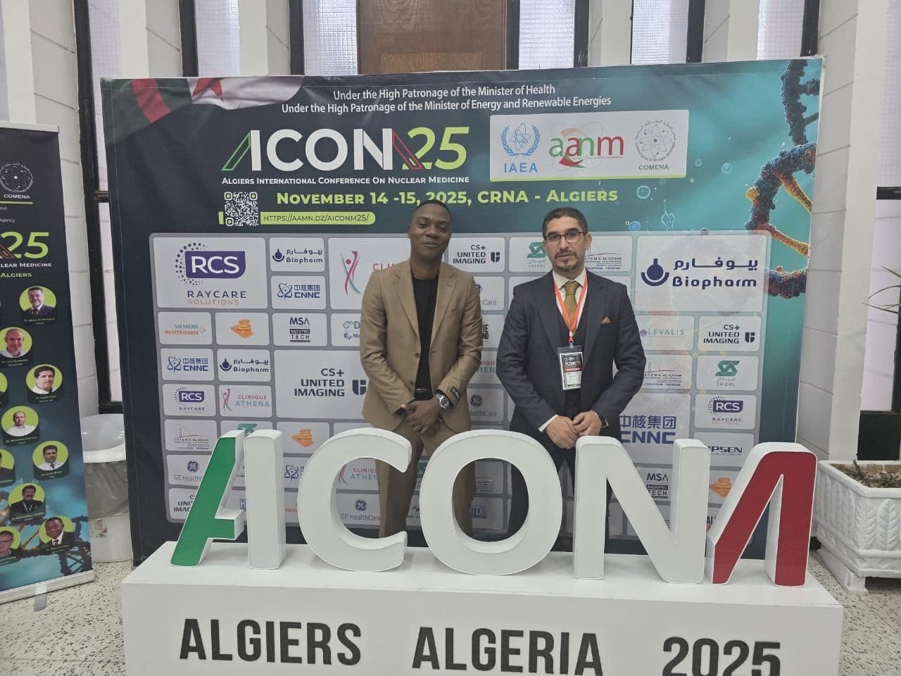 At the ACON25 conference booth, with a colleague, in front of the ACONM lettering.