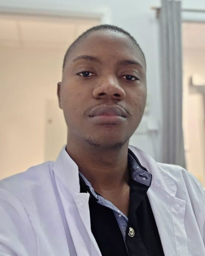 Portrait in a white medical coat in a clinical corridor.